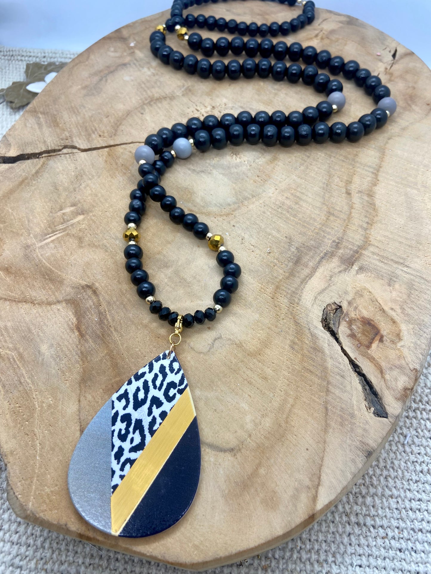 Sautoir en bois noir avec détails dorés pendentif léopard